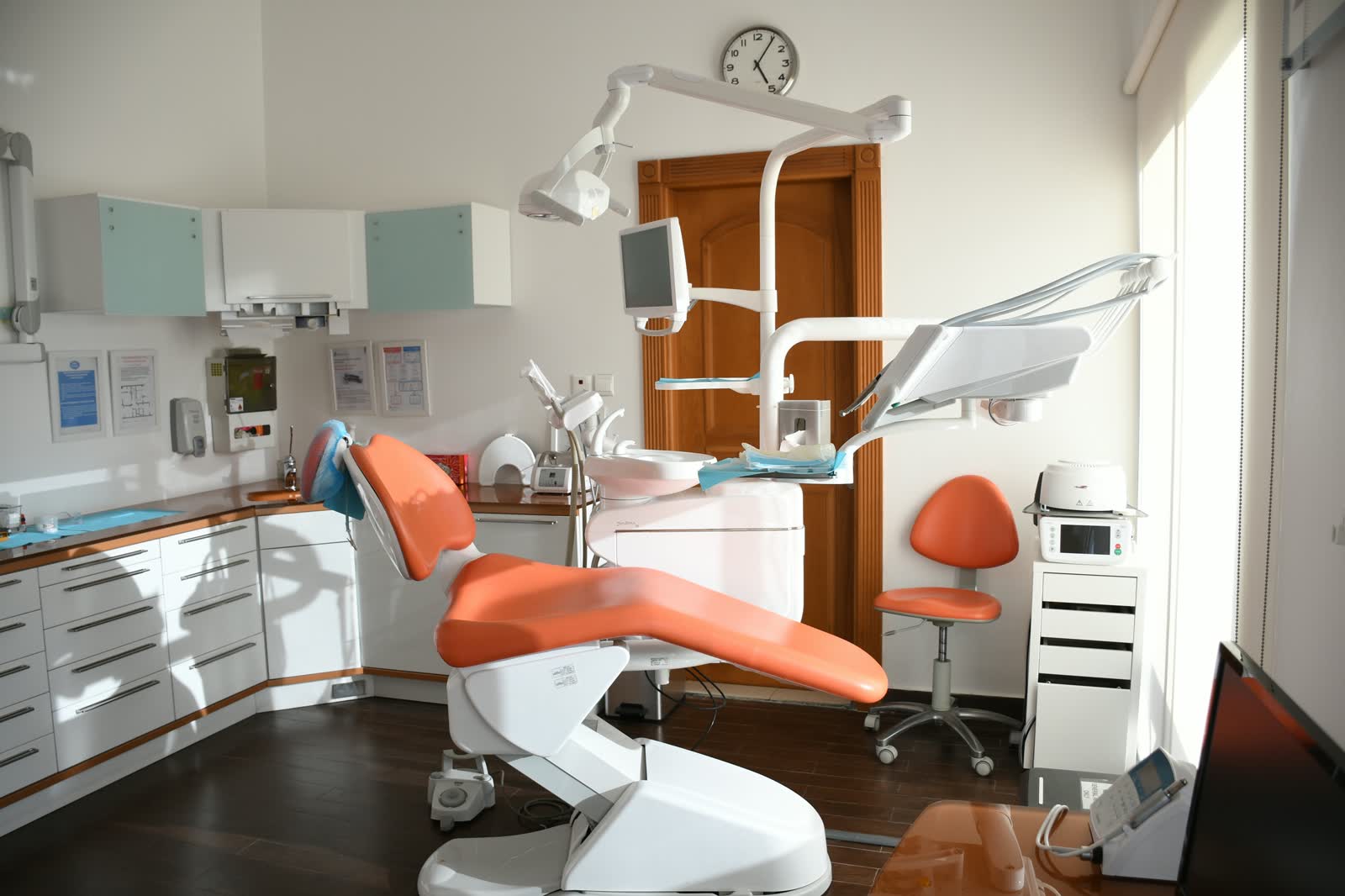 Dentist treating a patient in a modern dental chair at a bright clinic